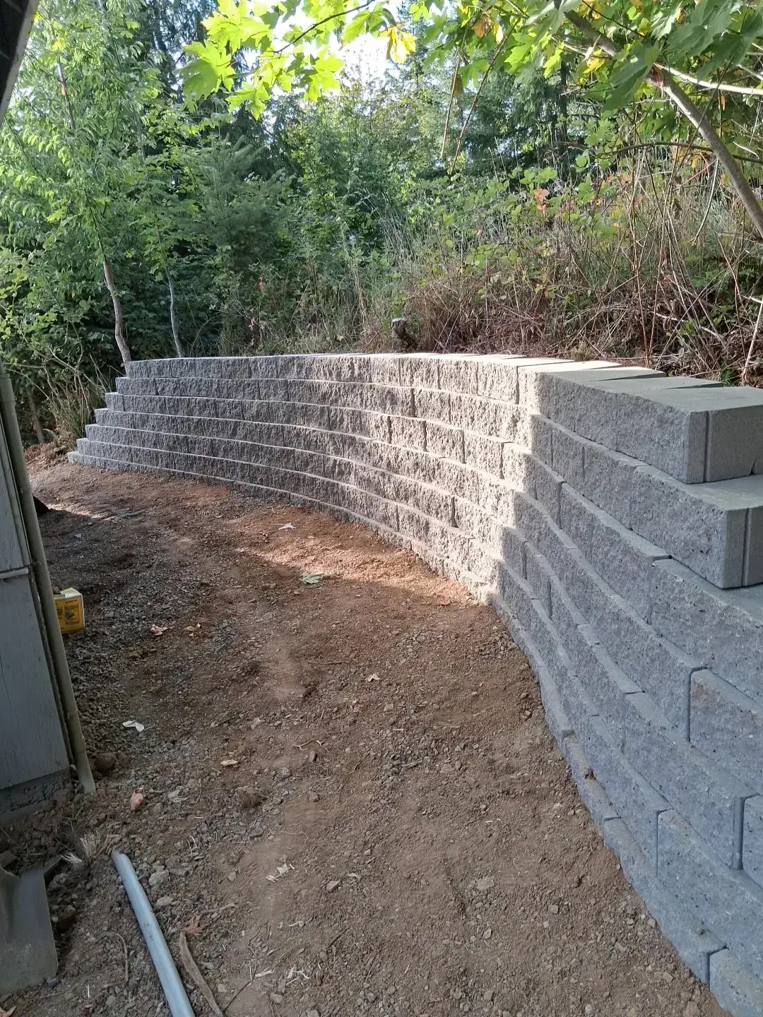 A block retaining wall running along a cut in a slope