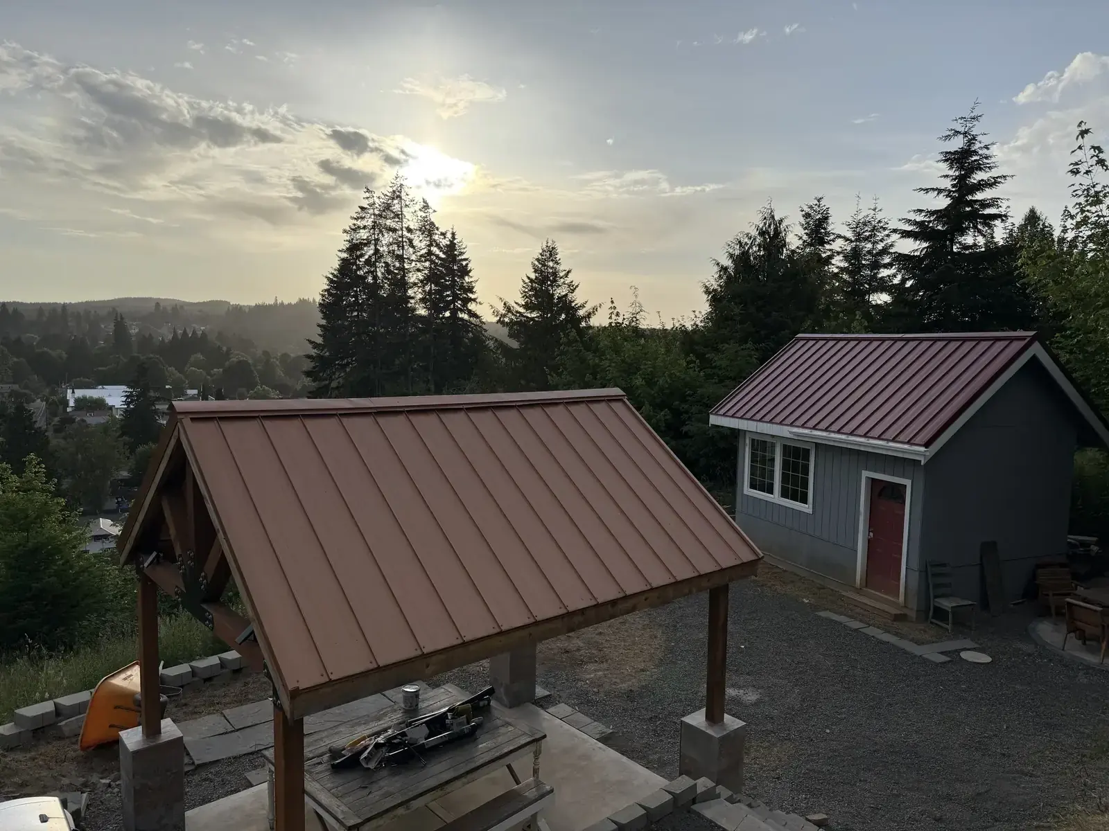 A copper pavilion roof and finished terrace seen from above, with the tiny house beyond