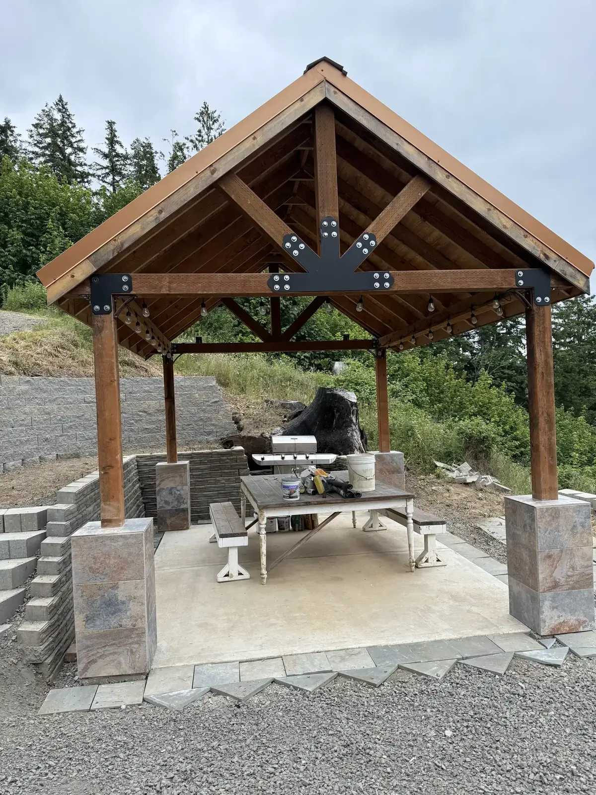 A timber pavilion on a new terrace with block steps and walls, on a hillside above the valley